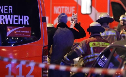 Firefighters attend an injured person after a truck ran into crowded Christmas market in Berlin, Germany, Monday. AP Photo