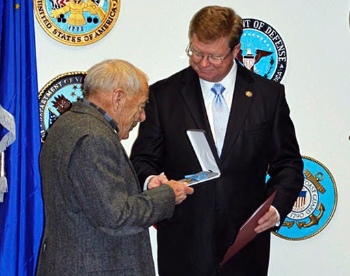 In this Monday, Dec. 19, 2016, photo provided by Stacey Parobek, Nevada Republican Rep. Mark Amodei, right, presents the Medal of Honor to Jerry Reynolds in Reno, Nev. Reynolds' grandfather, who was born Harry Reynolds but was known in the Army by his alias Pvt. Robert Smith, died before knowing he won the prestigious award for bravery during a battle in the Dakota Territory in 1876. (Stacey Parobek via AP)
