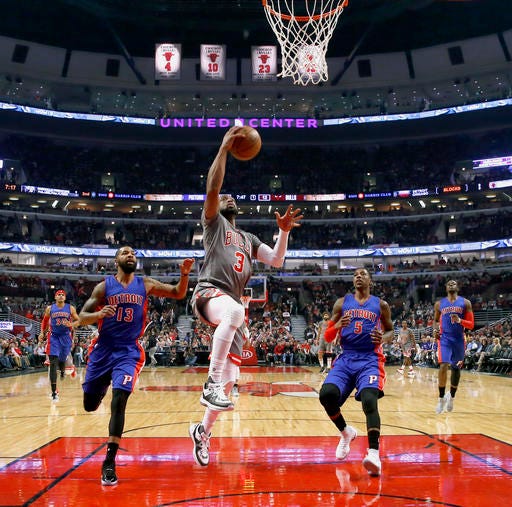 Chicago Bulls' Dwyane Wade (3) scores past Detroit Pistons' Marcus Morris (13) and Kentavious Caldwell-Pope during the first half of an NBA basketball game Monday, Dec. 19, 2016, in Chicago. (AP Photo/Charles Rex Arbogast)