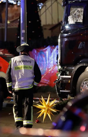 A firefighter walks past a star after a truck ran into crowded Christmas market in Berlin, Germany, Monday, Dec. 19, 2016, killing several people. (AP Photo/Michael Sohn)