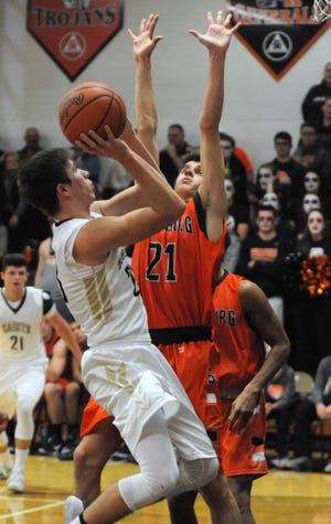 TIMES-REPORTER PAT BURK

Dean Green of TCC shoots as Nick Walczak of Strasburg tries to block during the game Tuesday night against Tuscarawas Central Catholic in New Philadelphia.