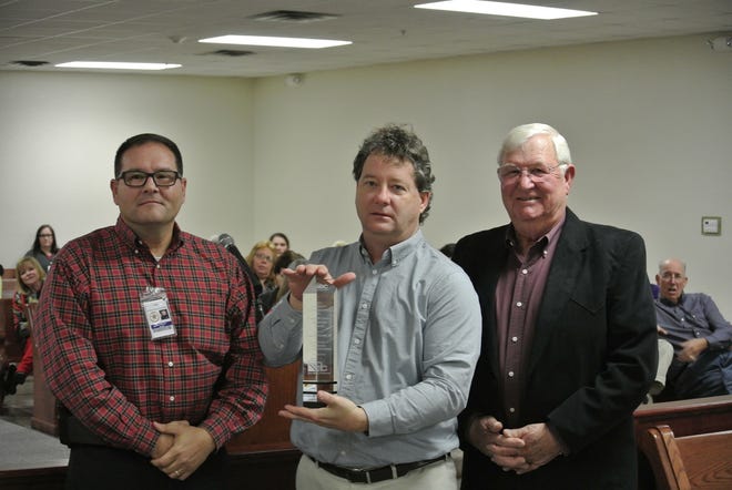 Crawford County Sheriff Ron Brown, left, Don Abernathy with Smith-Doyle Contractors, center, and Crawford County Judge John Hall pose with an award granted by the Association of Builders and Contractors for the new Crawford County jail at the Crawford County Quorum Court regular meeting Monday, Dec. 19, 2016. THOMAS SACCENTE/TIMES RECORD