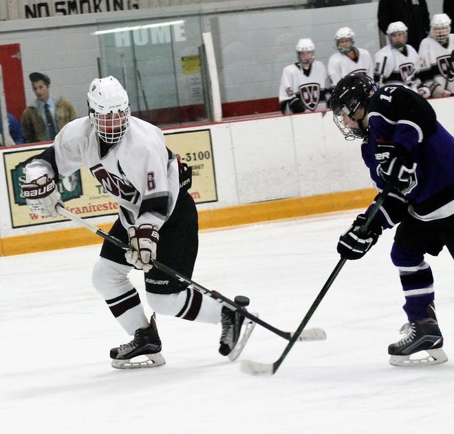 Noble's Evan Whitten, left, and Marshwood's Eli Janetos battle for a loose puck during Maine Class A South action Wednesday in Rochester. Al Pike photo
