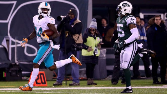 EAST RUTHERFORD, NJ - DECEMBER 17: Jarvis Landry #14 of the Miami Dolphins scores a touchdown against the New York Jets during the third quarter of the game at MetLife Stadium on December 17, 2016 in East Rutherford, New Jersey. (Photo by Al Bello/Getty Images)
