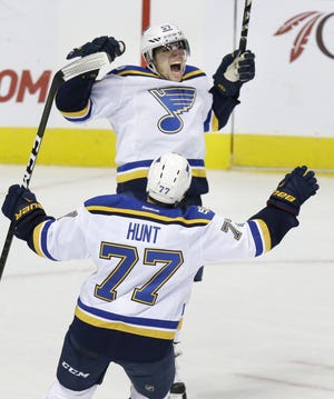 The Blues' David Perron, facing camera, celebrates with teammate Brad Hunt after Perron scored the game-winning goal during overtime Tuesday night as visiting St. Louis beat the Dallas Stars 3-2 LM OTERO/THE ASSOCIATED PRESS