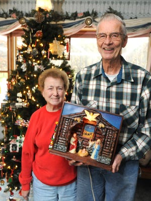 TIMES-REPORTER PAT BURK

Jim and Judy Wolff of Newcomerstown show a nativity scene that Jim bought with money from his paper route in 1950.