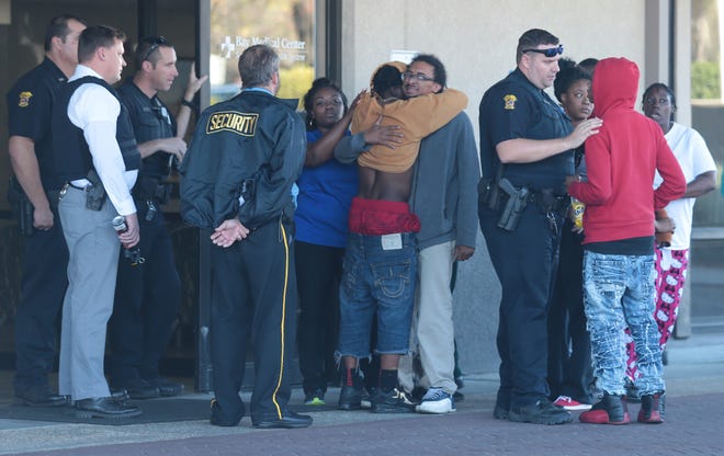 People hug and speak to police outside of the ER at Bay Medical Sacred Heart after a fatal shooting Wednesday on Hamilton Avenue in Panama City. PATTI BLAKE/THE NEWS HERALD