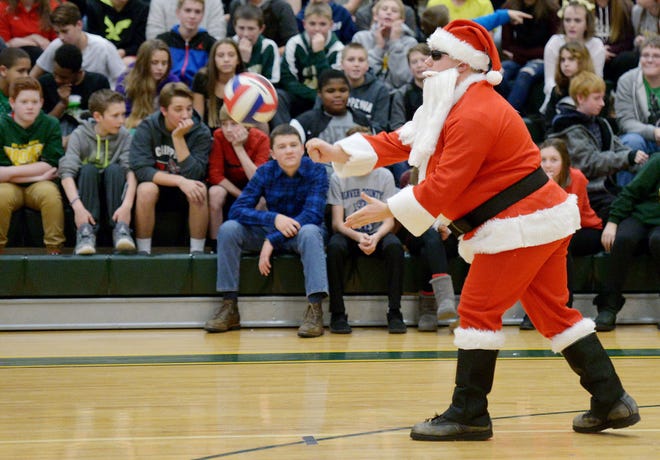 Social studies teacher Dan Nolte, dressed as Santa Claus, serves in a volleyball game between teachers and seventh-graders during an assembly Wednesday at Highland Middle School to recognize student efforts to raise money for the Salvation Army and The Times' Give a Christmas fundraising campaign.