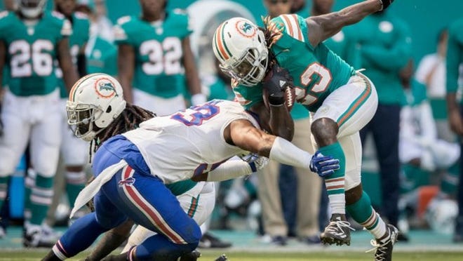 Miami Dolphins running back Jay Ajayi (23) runs over Buffalo Bills inside linebacker Zach Brown (53) at Hard Rock Stadium in Miami Gardens, Florida on October 23, 2016. (Allen Eyestone / The Palm Beach Post)
