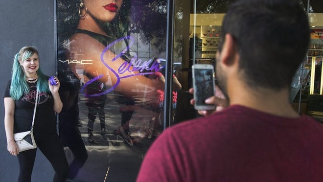 Felicia Cisneros poses for her boyfriend Michael Ramirez outside of the MAC store at the Domain in North Austin after purchasing two orders of the new line of makeup dedicated to the late singer Selena Quintanilla. RICARDO B. BRAZZIELL/AMERICAN-STATESMAN