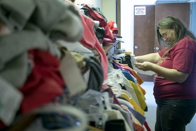 Volunteer Crystal Cooper sorts through a rack of clothing during the Salvation Army Christmas distribution at the Salvation Army Chapel at 510 N. Kellogg St. on Wednesday. STEVE DAVIS/The Register-Mail
