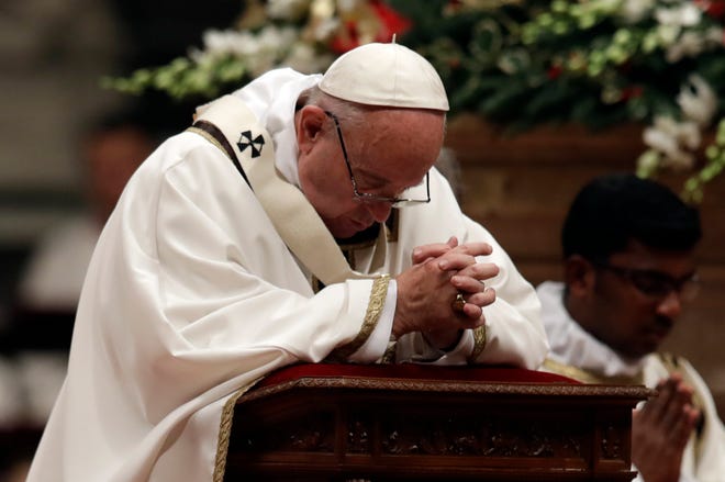 Pope Francis kneels as he celebrates the Christmas Eve Mass in St. Peter’s Basilica at the Vatican, Saturday, Dec. 24, 2016. (AP Photo/Alessandra Tarantino)