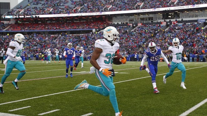 Miami Dolphins running back Kenyan Drake (32) rushes past Buffalo Bills' Corey Graham (20) for a touchdown during the first half of an NFL football game, Saturday, Dec. 24, 2016, in Orchard Park, N.Y. (AP Photo/Bill Wippert)