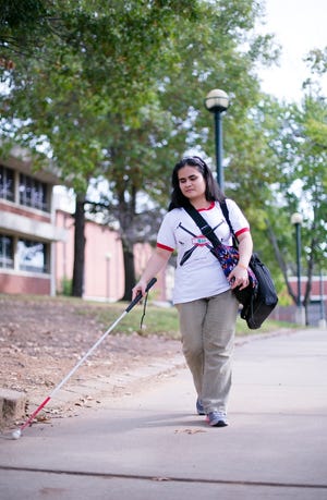 Blind student Trang Ha, originally from Vietnam, makes her way through the University of Arkansas at Fort Smith campus. COURTESY PHOTO/UAFS