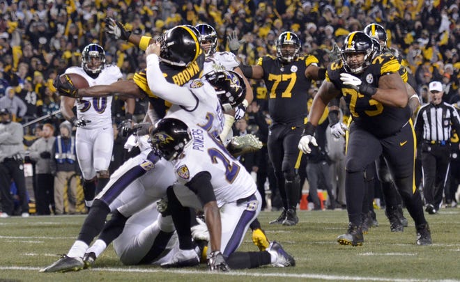 Steelers receiver Antonio Brown (84) reaches into the end zone for a touchdown as Baltimore's Eric Weddle (32) tries to hold him back during the Steelers' 31-27 win over the Baltimore Ravens on Christmas Sunday at Heinz Field in Pittsburgh.