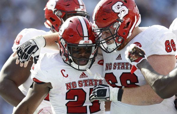 N.C. State's Joe Scelfo, right, congratulates Matthew Dayes after he scored a touchdown against North Carolina in November.