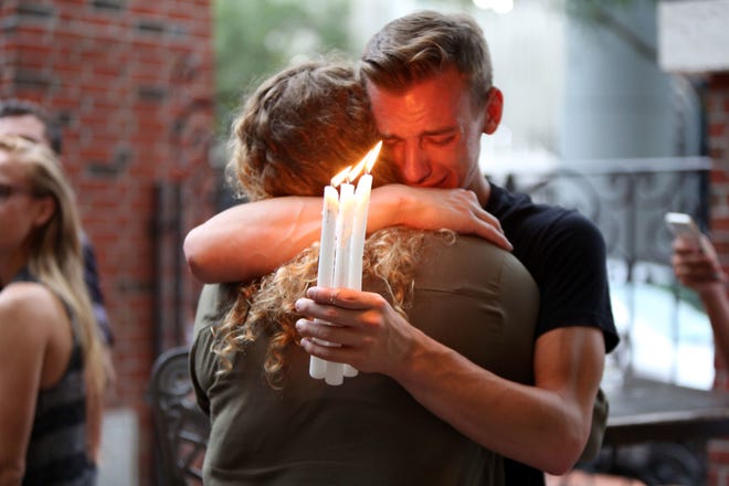 Brett Morian hugs a fellow mourner June 12 during a candlelight vigil for those killed at the Pulse nightclub in Orlando. AP FILE