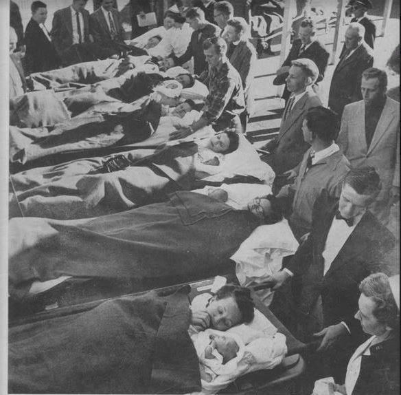 Last week's photo: Much of the community pitched in for the move of patients to the new Druid City Hospital from Northington. Coroner Rufus Strickland and funeral homes helped move the stretchers in hearses. The Tuscaloosa High School coaches and football team pitched in. The man in the plaid shirt with arm outstretched arm may be Jack McGuire. Faye Booth and infant William are second stretcher from the camera. Ruby Richardson and infant Anne are third stretcher from the camera. The chaplain near the back is Bishop George Murray of Canterbury Episcopal Church. The nurse in the back of the picture is Bettie Ann Cleino, director of the University of Alabama School of Nursing. The white-haired man in the dark suit in the upper right corner of the photo is Capt. T.R. "Mokie" Mayes of the Tuscaloosa Police Department.