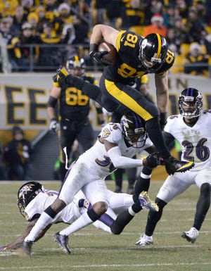 Steelers tight end Jesse James (81) hurdles the Ravens' Tavon Young (36) after a catch for a first down during the Steelers' 31-27 win over the Baltimore Ravens on Christmas Sunday at Heinz Field in Pittsburgh.