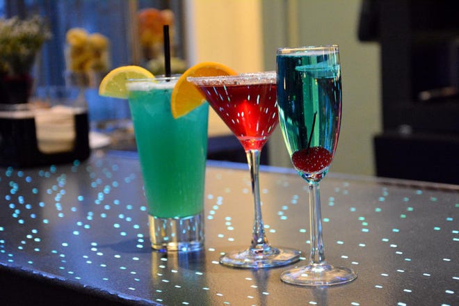 A few of the Signature Sips that served at Aloft Mount Laurel's WXYZ bar (from left) Electrical Lemonade, made with vodka, blue Curacao, sour, club soda, pineapple juice on the rocks, garnished with lemon; Pomtini, made with Stoli blueberry, pomegranate juice, PAMA liqueur, cranberry juice, garnished with an orange slice; Something Blue made with Champagne, Malibu coconut rum and blue Curacao, garnished with a cherry.