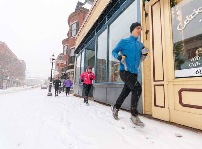 Runners from the Coastal Athletic Association plow through last Saturday's snowstorm. Most winter runners are training for a marathon. Photo by Kathy Eow