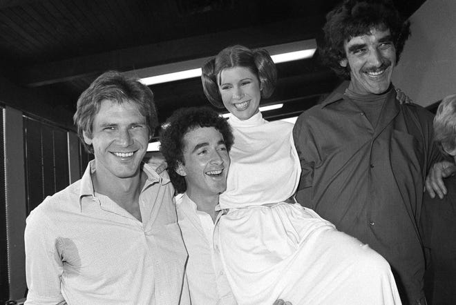 In this Oct. 5, 1978 photo, from left, actors Harrison Ford, Anthony Daniels, Carrie Fisher and Peter Mayhew take a break from filming a television special in Los Angeles to be telecast during the holidays. On Tuesday, Dec. 27, 2016, a publicist says Fisher has died at the age of 60. (AP Photo/George Brich, File)