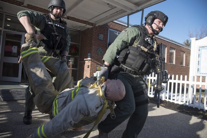 Members of the Strafford County Regional Tactical Operations Unit carry out a training dummy that represents a wounded police officer as they conduct active shooter training with the Lee Police Department at Mast Way School. Photo by John Huff/Fosters.com