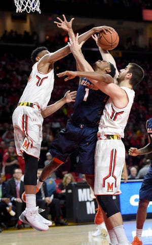 Illinois guard Jaylon Tate (1) is stopped by Maryland forward Ivan Bender, right, and Justin Jackson, left, during the first half of an NCAA college basketball game, Tuesday, Dec. 27, 2016, in College Park, Md. (AP Photo/Nick Wass)
