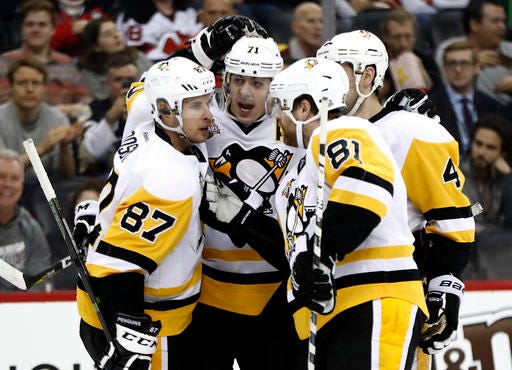 Pittsburgh Penguins celebrate a goal by center Evgeni Malkin, second from left, of Russia, during the first period of an NHL hockey game against the New Jersey Devils, Tuesday, Dec. 27, 2016, in Newark, N.J. (AP Photo/Julio Cortez)