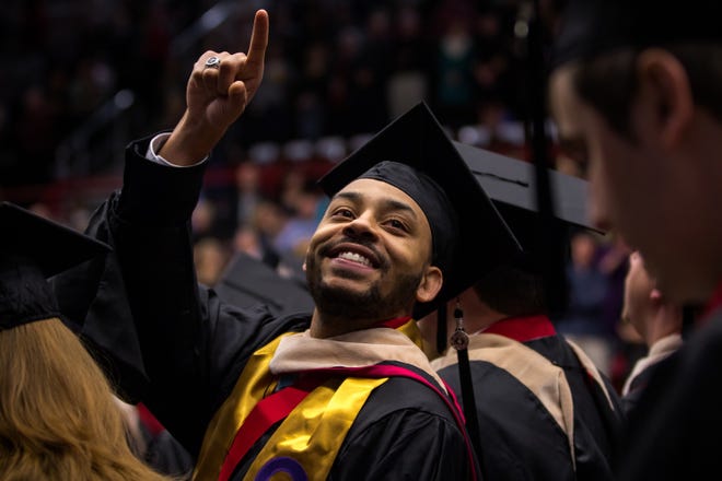A Gardner-Webb grad points up to the crowd during the commencement ceremony Dec. 19. Special to The Star