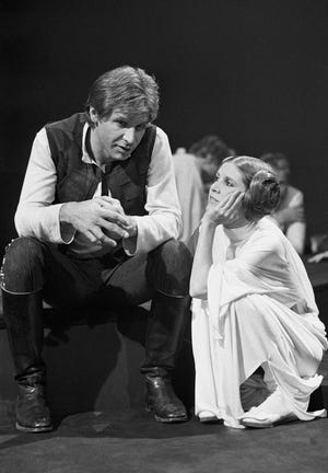 FILE - In this Nov. 13, 1978 file photo, Harrison Ford talks with Carrie Fisher during a break in the filming of the CBS-TV special "The Star Wars Holiday" in Los Angeles. On Tuesday, Dec. 27, 2016, a publicist says Fisher has died at the age of 60. (AP Photo/George Brich, File)