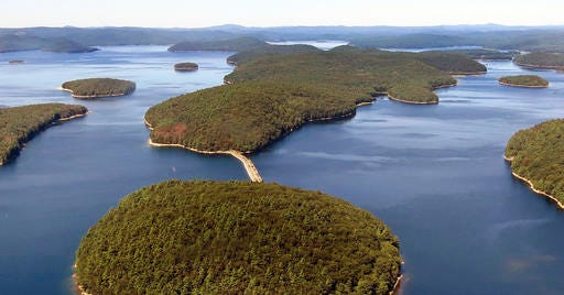 FILE - In this September 2013 aerial file photo provided by the Massachusetts Deptartment of Conservation and Recreation, a dirt and stone road leads to Mount Zion Island, at rear, at the Quabbin Reservoir in Petersham, Mass. A plan by the state to start a colony of venomous timber rattlesnakes on the off-limits island in the state's largest drinking water supply came under fire, and became one of New England's odd stories in 2016. (Clif Read, The Mass. Dept. of Conservation and Recreation via AP, File)