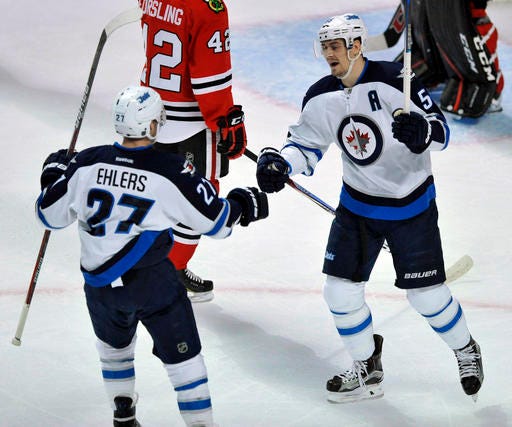 Winnipeg Jets' Mark Scheifele (55) celebrates with teammate Nikolaj Ehlers (27) after scoring a goal during the first period of an NHL hockey game against the Chicago Blackhawks Tuesday, Dec. 27, 2016, in Chicago. (AP Photo/Paul Beaty)