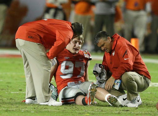 FILE - This Jan. 3, 2014 file photo shows Ohio State defensive lineman Joey Bosa being attended to after a play during the first half of the Orange Bowl NCAA college football game between Clemson and Ohio State in Miami Gardens, Fla. Ohio State's defense had been laid to waste by Clemson in the 2014 Orange Bowl, the last in a series of lousy performances by the Buckeyes that caused a promising season to end with a thud. When No. 2 Ohio State (11-1, No. 3 CFP) faces No. 3 Clemson (12-1, CFP No. 2) in the Fiesta Bowl semifinal on Saturday at University of Phoenix Stadium, the Tigers will be dealing with a very different animal. (AP Photo/Wilfredo Lee, file)