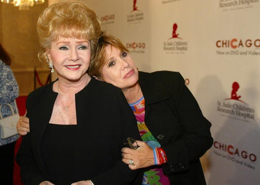 FILE - In this Tuesday, Aug. 19, 2003 file photo, Debbie Reynolds and Carrie Fisher arrive at the "Runway for Life" Celebrity Fashion Show Benefitting St. Jude's Children's Research Hospital and celebrating the DVD relese of Chicago in Beverly Hills, Calif. On Tuesday, Dec. 27, 2016, a publicist said Fisher has died at the age of 60. (AP Photo/Jill Connelly, File)