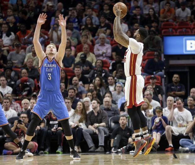 Miami's James Johnson, right, puts up a shot while Oklahoma City's Domantas Sabonis defends during Tuesday night's game in Miami. Oklahoma City defeated the Heat, 106-94.