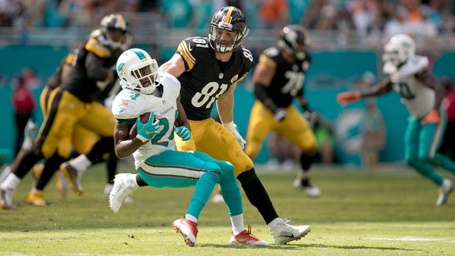 Miami Dolphins strong safety Isa Abdul-Quddus (24) is tackled by Pittsburgh Steelers tight end Jesse James (81) after interepting a pass in the third quarter at Hard Rock Stadium in Miami Gardens, Florida on October 16, 2016. (Allen Eyestone / The Palm Beach Post)