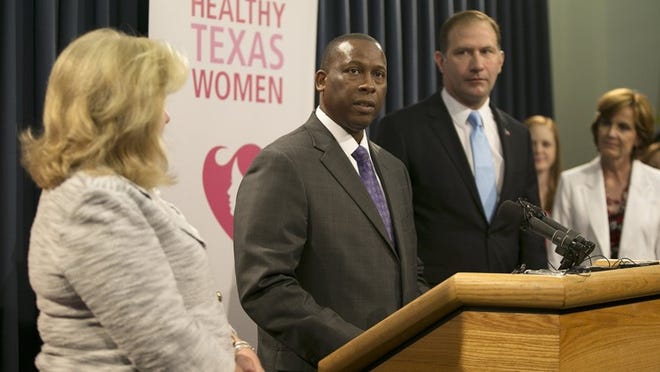 Charles Smith, executive commissioner of the Texas Health and Human Services Commission, standing at a lectern, is one of the defendants in a lawsuit filed by CVS alleging that Texas officials wrongly targeted the pharmacy chain in a Medicaid fraud investigation.