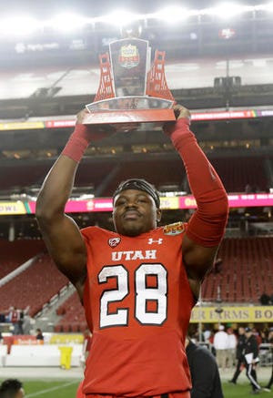 Utah running back Joe Williams holds the game's offensive MVP trophy after Utah's 26-24 win over Indiana in the Foster Farms Bowl NCAA college football game Wednesday, Dec. 28, 2016, in Santa Clara, Calif. (AP Photo/Marcio Jose Sanchez)