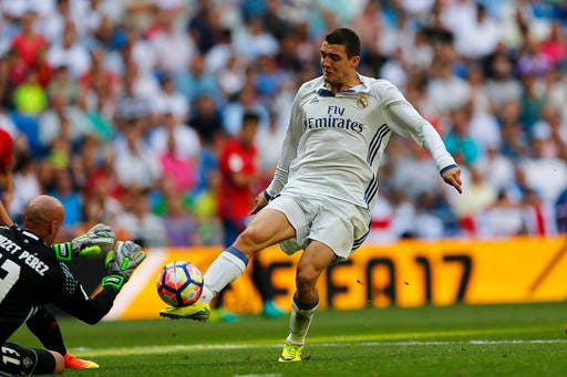 FILE - In this file photo dated Saturday, Sept. 10, 2016, Real Madrid's Mateo Kovacic, right, challenges Osasuna's goalkeeper Nauzet Perez during the Spanish La Liga soccer match at the Santiago Bernabeu stadium in Madrid. Real Madrid issued medical reports Thursday Dec. 29, 2016, stating midfielder Mateo Kovacic will be sidelined because of injuries sustained during the recent Club World Cup, along with forward Lucas Vazquez. (AP Photo/Francisco Seco, FILE)