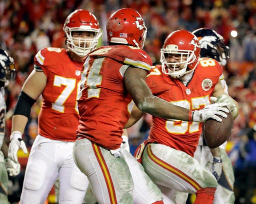 FILE - In a Dec. 25, 2016 file photo, Kansas City Chiefs tight end Travis Kelce, right, celebrates with tight end Demetrius Harris (84), after Harris caught a touchdown pass against the Denver Broncos during the second half of an NFL football game in Kansas City, Mo. The beginning of the end for the defending champions Broncos came in Week 12 in a frigid classic. The Broncos blew an eight-point lead over Kansas City and lost 30-27 when Cairo Santos banked a field goal as overtime expired. (AP Photo/Charlie Riedel, File)