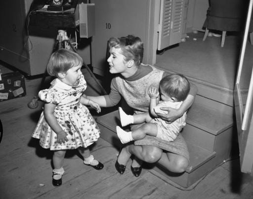 FILE- In this Feb. 27, 1959, file photo, working long hours on the set of "Say One For Me," so she can fly to Spain and start another movie, actress Debbie Reynolds is visited at the studio by her children, Carrie, 2, and 1-year-old Todd. Reynolds, star of the 1952 classic "Singin' in the Rain" died Wednesday, Dec. 28, 2016, according to her son Todd Fisher. She was 84. (AP Photo, File)