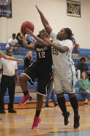 Shelby's Saniya Watkins goes for a layup against Ashbrook's Shajada Barrett in the Lady Bulldogs' Holiday Classic championship game Thursday night at Burns. Ashbrook won the event for the second year, defeating Shelby, 63-37. Hannah Dunaway/The Star