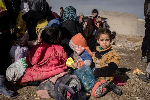 Iraqis displaced from Mosul wait for transportation to IDP camps, near Bartella, Iraq on Thursday, Dec. 29, 2016. Breaking a two-week lull in fighting, Iraqi troops backed by the U.S.-led coalition's airstrikes and artillery pushed deeper into eastern Mosul on Thursday in a multi-pronged assault against Islamic State militants in the city. (AP Photo/Cengiz Yar)