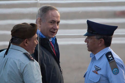 Israel's Prime Minister Benjamin Netanyahu, center, Israel's Chief of Staff Lt. Gen. Gadi Eizenkot, left, and Israel's air force commander Maj.General Amir Eshel attend a graduation ceremony for new pilots in the Hatzerim air force base near the city of Beersheba, Israel, Thursday, Dec. 29, 2016. Israel's Justice Ministry and police say they will issue an update "in due time" about an ongoing probe into suspicions surrounding Prime Minister Benjamin Netanyahu. (AP Photo/Ariel Schalit)