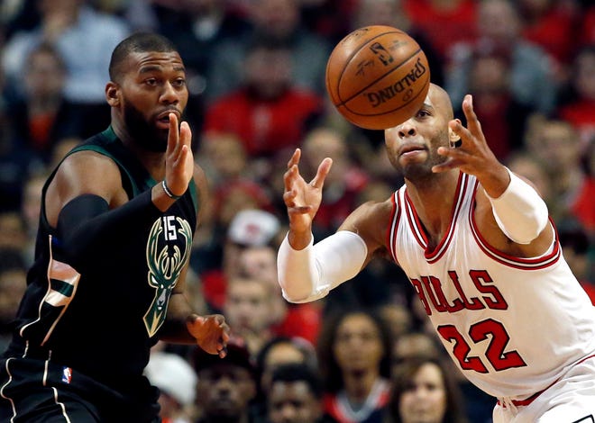 Chicago Bulls forward Taj Gibson, right, reaches for the ball next to Milwaukee Bucks' Greg Monroe during the first half of an NBA basketball game Saturday, Dec. 31, 2016, in Chicago. (AP Photo/Nam Y. Huh)