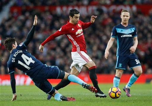 Middlesbrough's Marten de Roon, left, challenges Manchester United's Henrikh Mkhitaryan center during their English Premier League soccer match at Old Trafford, Manchester, England, Saturday, Dec. 31, 2016. (Martin Rickett/PA via AP)