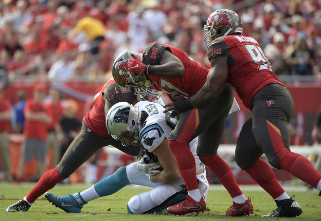 Carolina Panthers tight end Greg Olsen (88) is stopped by Tampa Bay Buccaneers strong safety Keith Tandy (37) and defensive tackle Clinton McDonald (98) during the first quarter Sunday in Tampa. THE ASSOCIATED PRESS / PHELAN EBENHACK