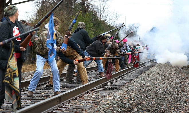 Members of the Cherryville New Years Shooters fire their muskets outside the Cherryville Railroad Depot on Monday morning. JOHN CLARK/THE GAZETTE