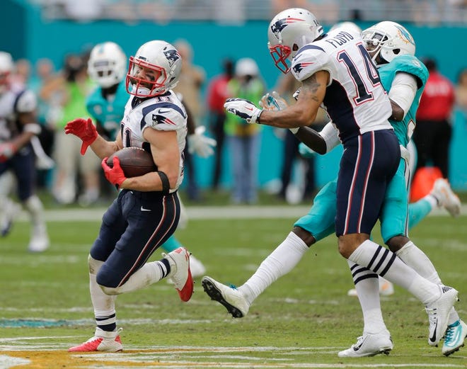 New England Patriots wide receiver Julian Edelman, left, runs for a touchdown as wide receiver Michael Floyd blocks Miami Dolphins cornerback Tony Lippett out of the way during the second half of an NFL football game, Sunday, Jan. 1, 2017, in Miami Gardens, Fla.